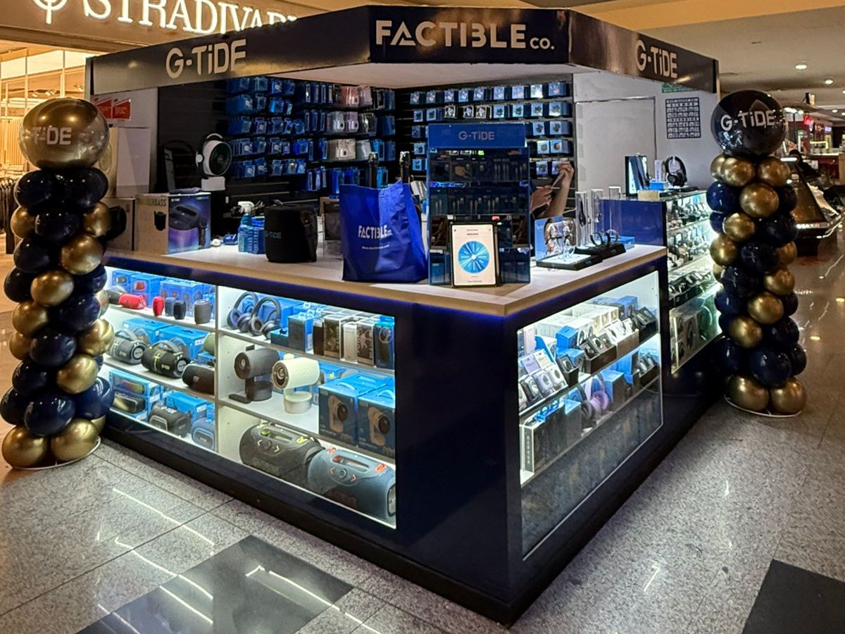 Módulo FACTIBLE co. y G-TiDE en Plaza Cosmopol, con vitrinas iluminadas de bocinas, audífonos y relojes